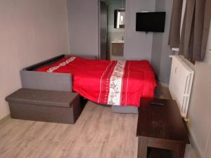 a small bedroom with a bed with a red blanket at le petit SAINT ANTOINE in Saint-Jean-de-Maurienne