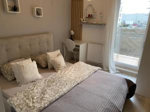 a bedroom with a bed and a desk and a window at Apartament Kacper in Gdańsk