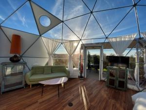 a living room with a green couch and a tv at Glamping Skies - Adults Only in Estremoz