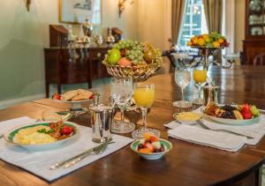 a table with plates of food and bowls of fruit at Linden - A Historic Bed and Breakfast in Natchez