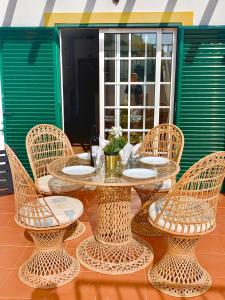 une table et des chaises en osier assises sur une terrasse dans l'établissement Casadaluz 18, à Luz