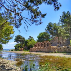 un ancien bâtiment en pierre sur la rive d'une rivière dans l'établissement mercan pension, à Olympos