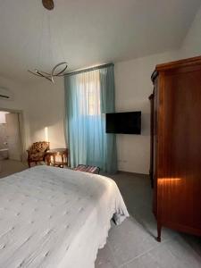 1 dormitorio con 1 cama y TV de pantalla plana en Palazzo Sabini, en Pertosa