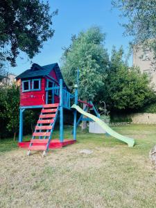 un parque infantil con tobogán y una casa en Palazzo Sabini, en Pertosa