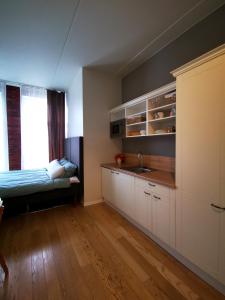 - une cuisine avec évier et un lit dans une chambre dans l'établissement Rotermanni Mere Apartment, à Tallinn