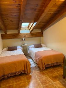 2 bedden in een kamer met houten plafonds bij Era de Parramon in Peramea