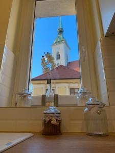 okno z widokiem na budynek z wieżą w obiekcie New Oldtown Apartment near St Martin Cathedral w Bratysławie