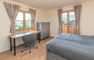 een slaapkamer met een bureau, een bed en ramen bij Rittersstuben in Garmisch-Partenkirchen