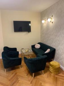salon z 2 krzesłami i telewizorem z płaskim ekranem w obiekcie New Oldtown Apartment near St Martin Cathedral w Bratysławie