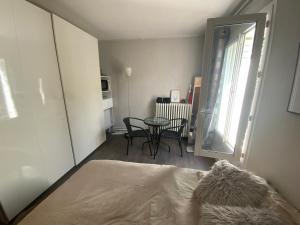 a bedroom with a bed and a table and a window at Belle chambre au calme centre Montpellier in Montpellier