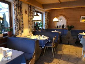 a dining room with blue booths and tables in a restaurant at Sportpension Therese in Westendorf