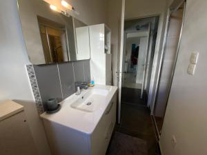 La salle de bains est pourvue d'un lavabo blanc et d'un miroir. dans l'établissement Belle chambre au calme centre Montpellier, à Montpellier