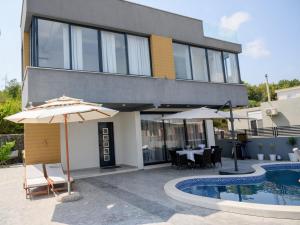 a building with a pool and a table and umbrellas at Luxury Scandinavian in Ulcinj