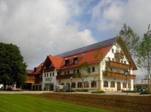 duży budynek z pomarańczowym dachem i dziedzińcem w obiekcie Hotel Straßhof w mieście Pfaffenhofen an der Ilm