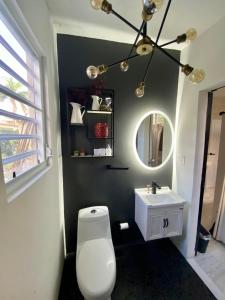 La salle de bains est pourvue de toilettes blanches et d'un lavabo. dans l'établissement Isla Verde by the Beach, à San Juan