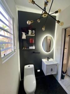 a bathroom with a white toilet and a sink at Isla Verde by the Beach in San Juan