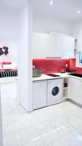 uma cozinha branca com uma máquina de lavar roupa em Cozy apartment in the center of Athens em Atenas