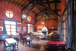 una sala da pranzo con tavoli, sedie e camino di Albergue de Espiel a Espiel Altre 56 foto