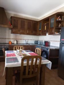 a kitchen with a table and chairs and a kitchen with a stove at Vila da Mesa in Algoz