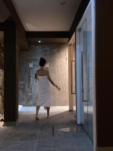 a woman in a white dress standing in a bathroom at Encanto Agriturismo & Private SPA in Visogliano