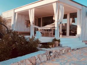 a house with white curtains on the front of it at BUQEZ ECO RESORT - Beach Villa 37 and 40 in Pakoštane