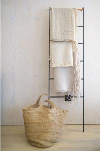 a towel rack with a basket and towels at BUQEZ ECO RESORT - Beach Villa 37 and 40 in Pakoštane