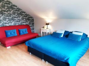 - une chambre avec deux lits et un canapé rouge dans l'établissement B&B Caprice d'Epices, à Francorchamps