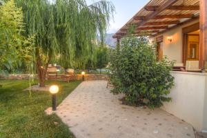 a garden with a patio with a tree and lights at Gasparakis Villas in Plakias