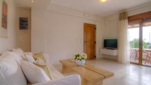 a living room with a couch and a table and a tv at Gasparakis Villas in Plakias