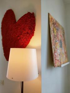 un cuore appeso a un muro accanto a una lampada di La casa del cuore - Luxury Apartment a Olgiate Comasco