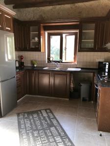 a kitchen with wooden cabinets and a sink and a window at The Goat house in Polis Chrysochous