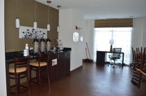 a kitchen with a bar with chairs and a desk at Sleep Inn & Suites Elk City in Elk City