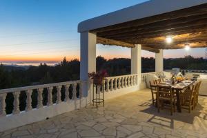 eine Terrasse mit Tisch und Stühlen auf einem Balkon in der Unterkunft Can March magic sunset in Ses Paisses