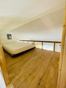 a bedroom with a bed and a wooden floor at Bel appartement avec mezzanine, vue mer et piscine in Cogolin