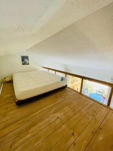 孔格林Bel appartement avec mezzanine, vue mer et piscine的铺有木地板的房间里的一张床