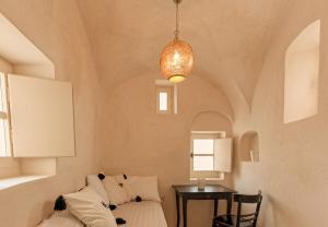 a room with a couch and a table with a lamp at Castelli Torre in Emporio Santorini