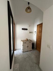 a hallway with a small cabinet in a room with a door at Calle de la Convalecencia in Córdoba