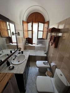a bathroom with a sink and a toilet and a tub at Calle de la Convalecencia in Córdoba