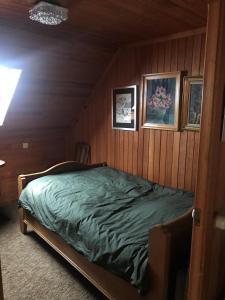 sypialnia z łóżkiem w drewnianej ścianie w obiekcie Home@Chiny w mieście Chiny