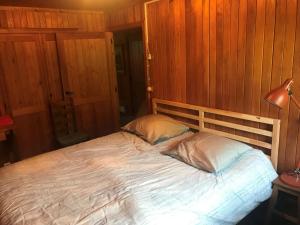 a bed with two pillows in a room with wooden walls at Home@Chiny in Chiny