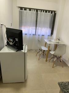 a living room with a tv and a table with chairs at Soya Departamentos PB A in Junín