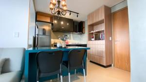 a kitchen with a blue table and black chairs at Flat The Expression 1705 in Goiânia