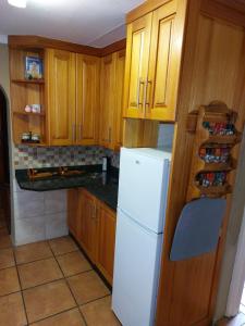 a kitchen with wooden cabinets and a white refrigerator at Anna Katarina in Sabie