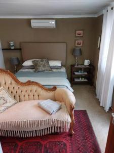 a bedroom with a bed with a couch and two lamps at Anna Katarina in Sabie