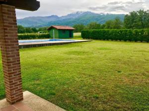 une cour verdoyante avec un petit bâtiment en arrière-plan dans l'établissement EL LLANO, à Candeleda