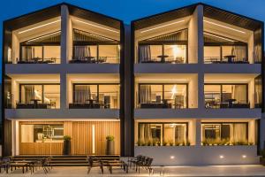an exterior view of a building with tables and chairs at Canale Hotel & Suites in Argostoli