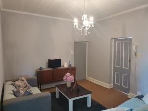 a living room with a couch and a table at Hartland Gastehuis/Guesthouse in Vredendal