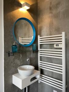 La salle de bains est pourvue d'un lavabo blanc et d'un miroir. dans l'établissement Residence St Jacques, à Clermont-Ferrand