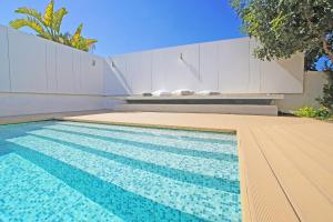 ein Pool mit einer Bank neben einem Haus in der Unterkunft Villa Indigo in Protaras