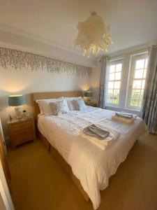 a bedroom with a large bed and two windows at Central St Andrews 2 bed apartment in St Andrews